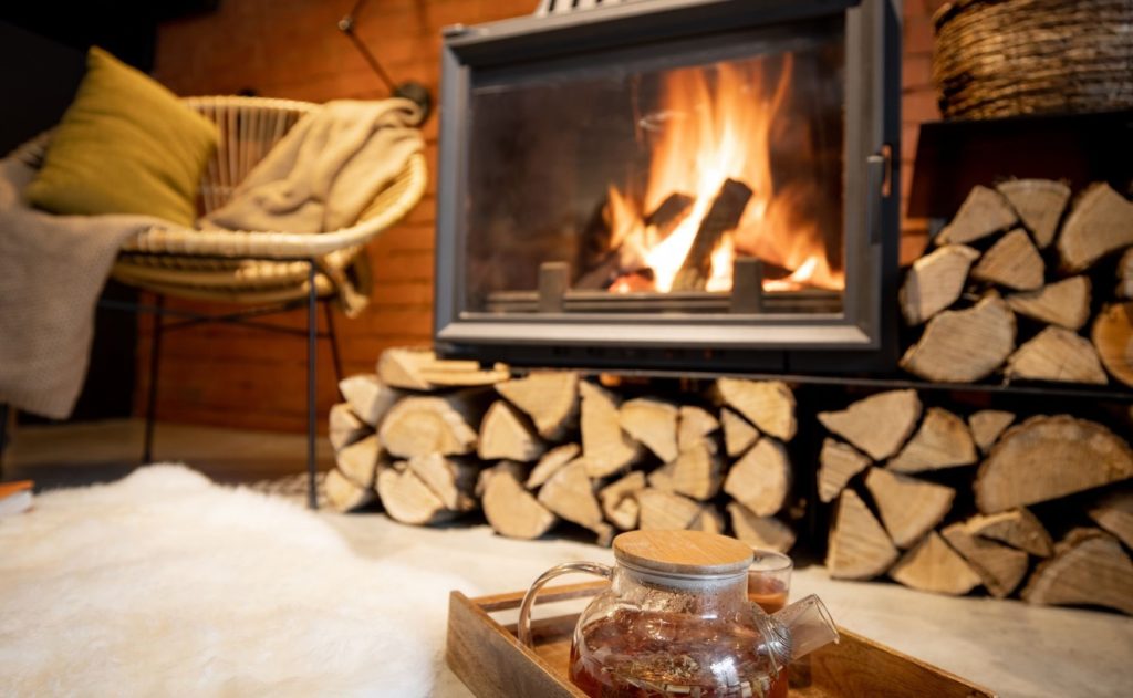 Ofen und Tee in Hütte mit Feuerholz