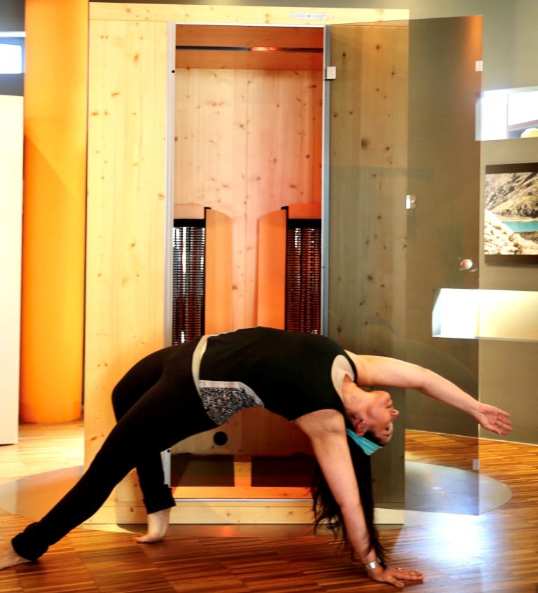 Frau macht vor Physiotherm Kabine Yoga