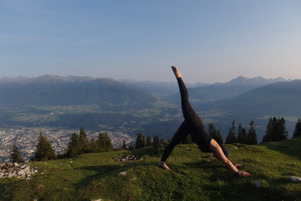 Frau macht Yoga am Berg